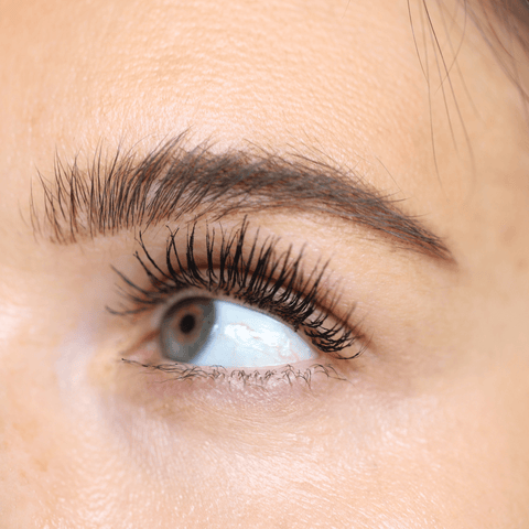 Close-up of an eye with dramatic, volumized lashes wearing Night Show Volumizing Mascara.