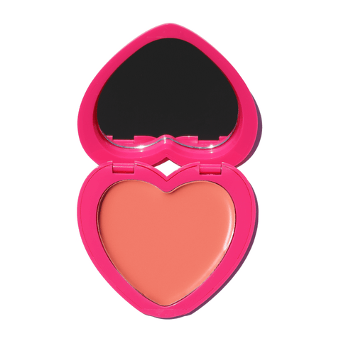 Heart-shaped Candy Paint Cheek + Lip Tint compact open to reveal a buildable, peach-toned cream blush with a mirror for easy, on-the-go application.